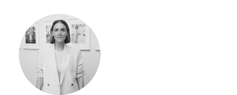 a woman in a white jacket standing in front of a wall