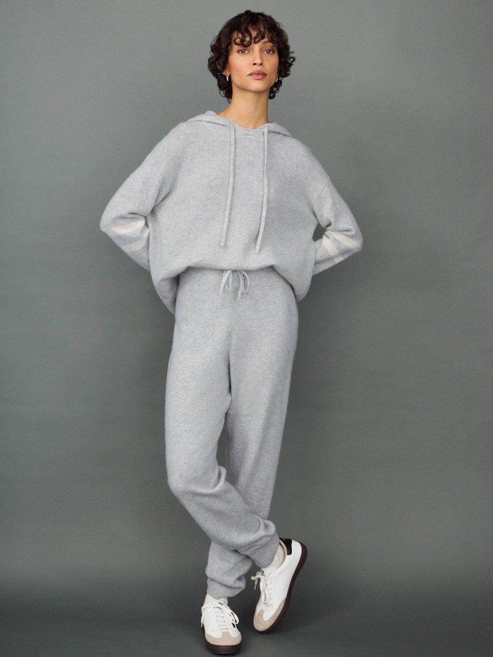 a woman in a grey sweatsuit posing for a photo