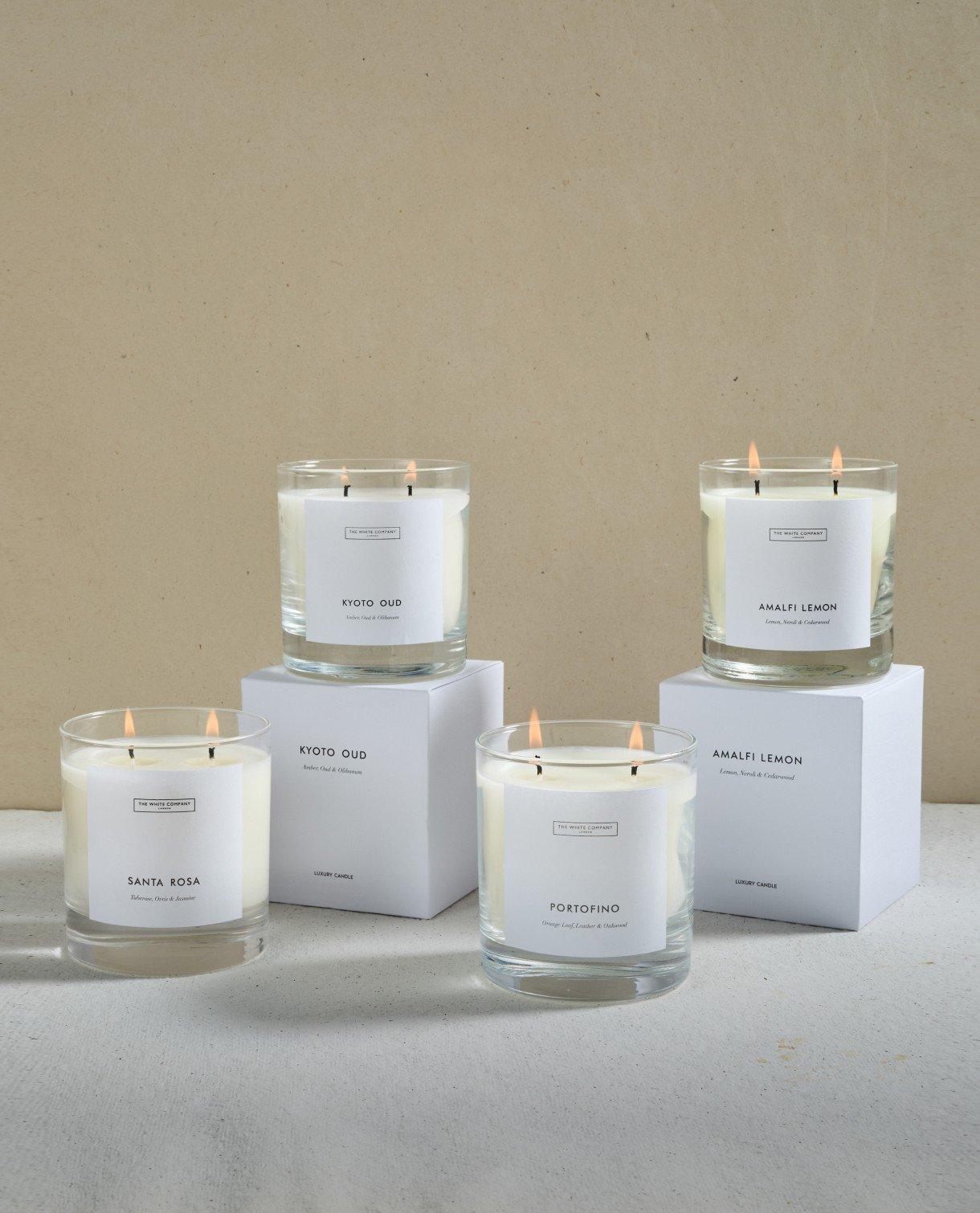 three candles on white boxes with labels on them