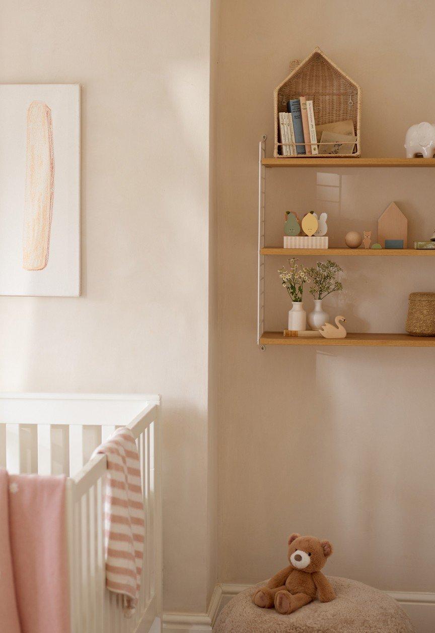 a baby's room with a crib, a changing table, and a teddy bear