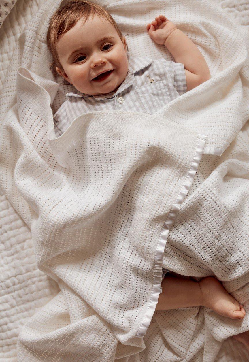 a woman holding a baby in a towel on a table