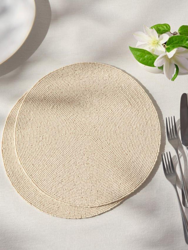 a table setting with a white cloth placemat and a white fork and knife