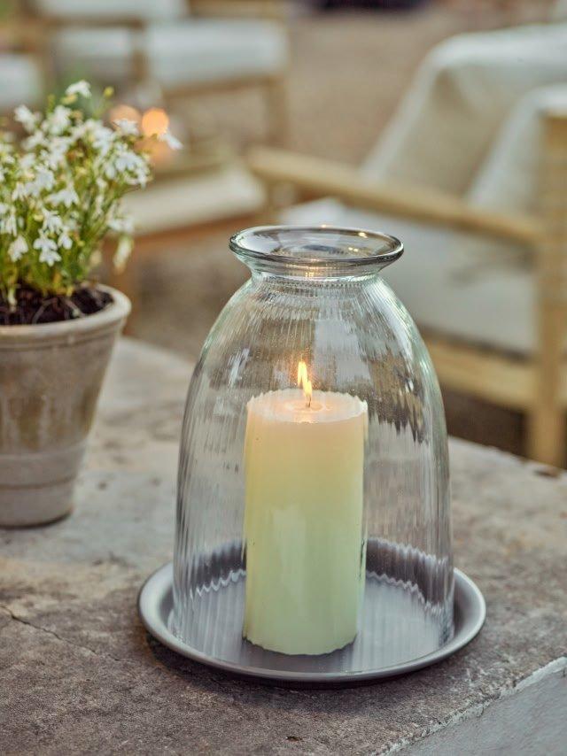 a candle sitting in a glass dome on a table