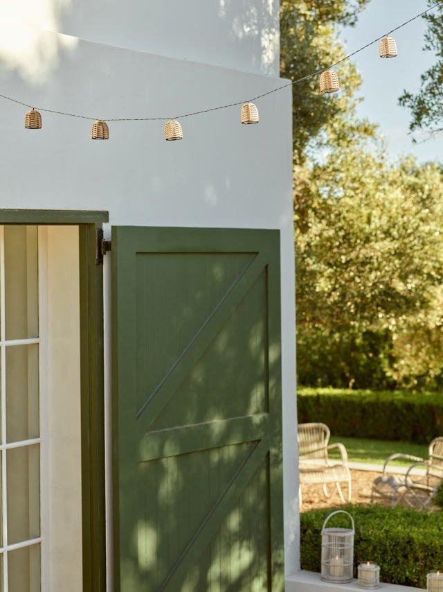 a green door with a string of lights hanging from it