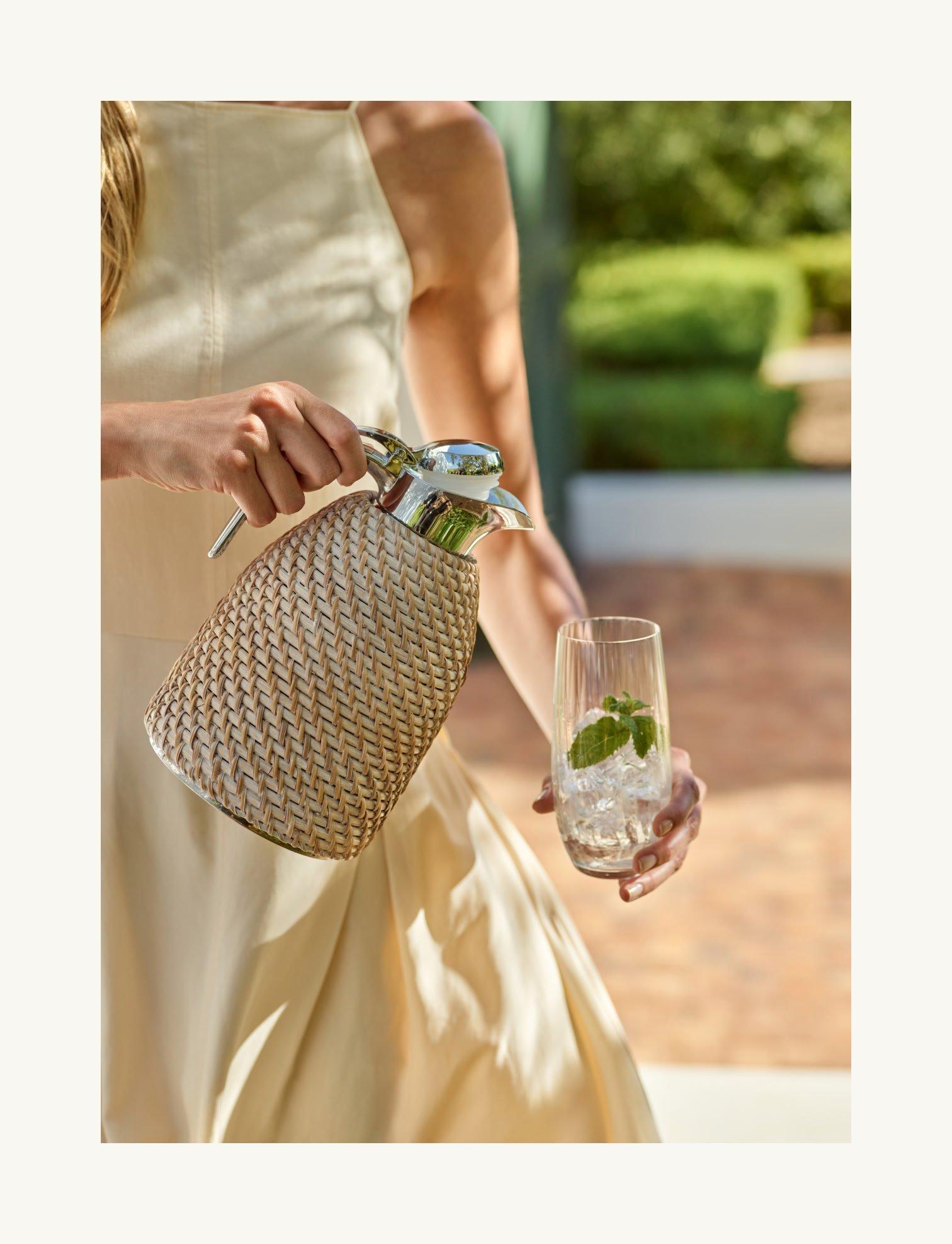 a woman holding a pitcher and a glass of water