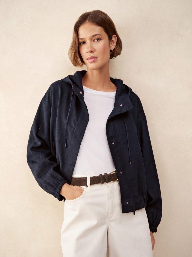 a woman in white shorts and a black jacket