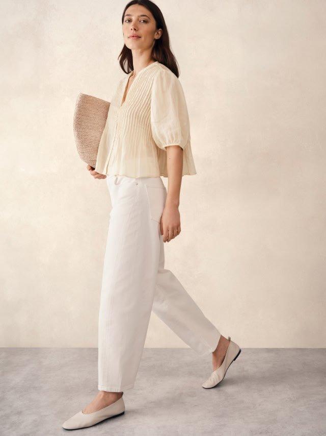 woman walking in white pants and a white top