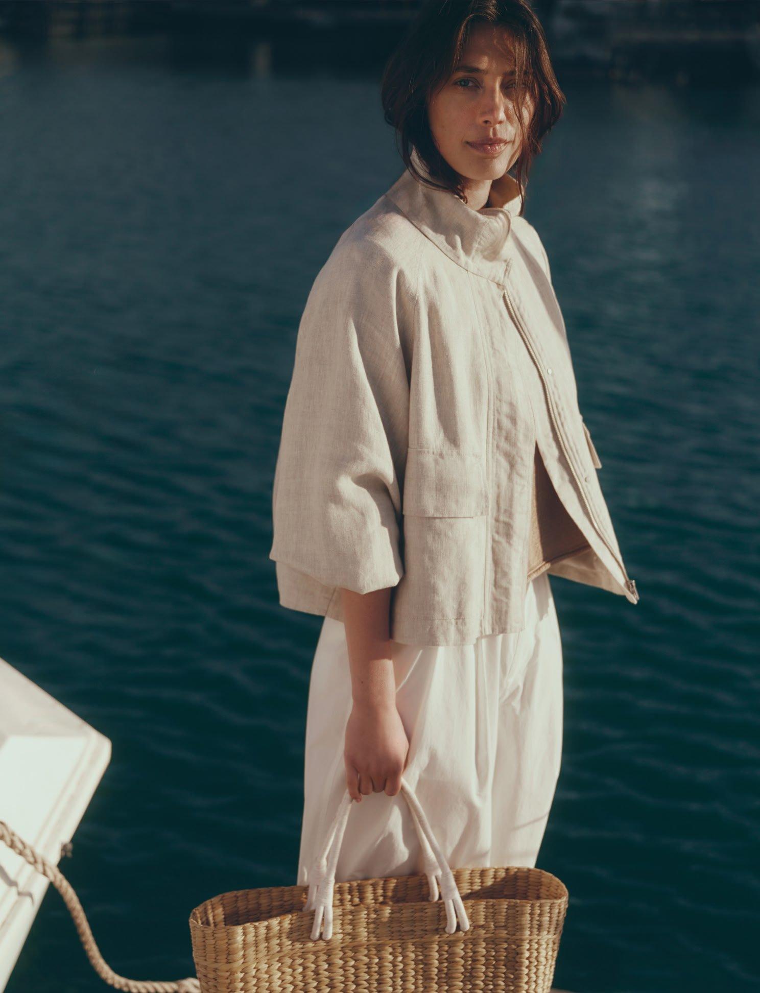 a woman walking on the water with a basket on her shoulder
