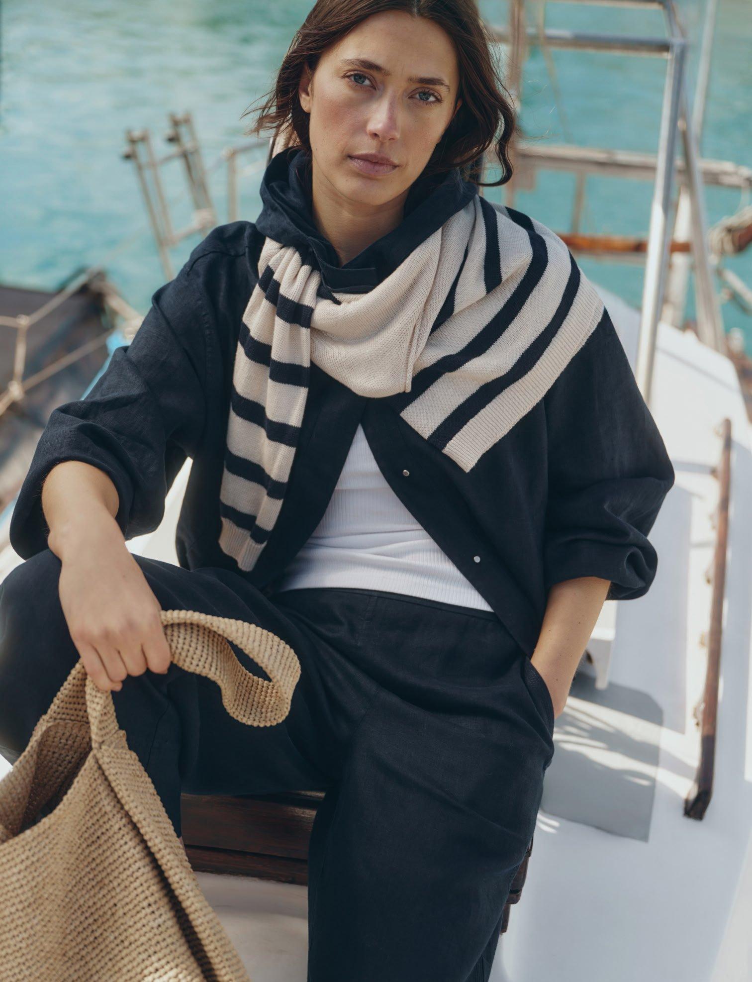 a woman sitting on a boat with a bag on her lap