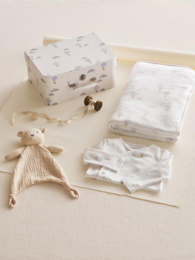 a baby's clothes and accessories are laid out on a table