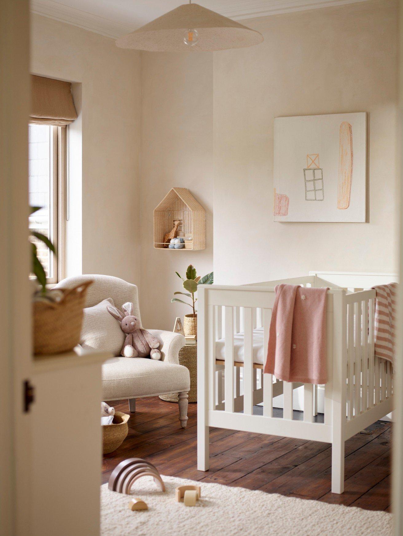 a baby's room with a crib, a chair, and a rug