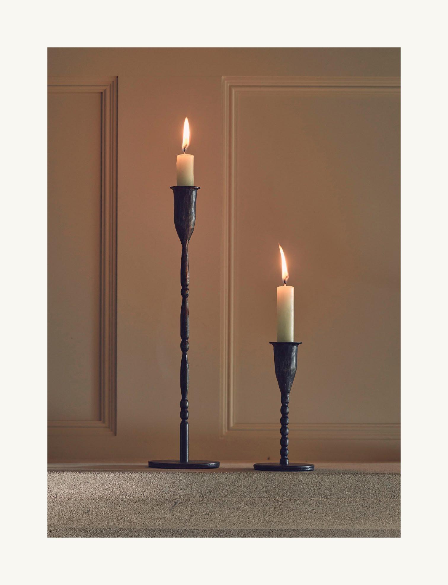 two candles are sitting on a table next to each other