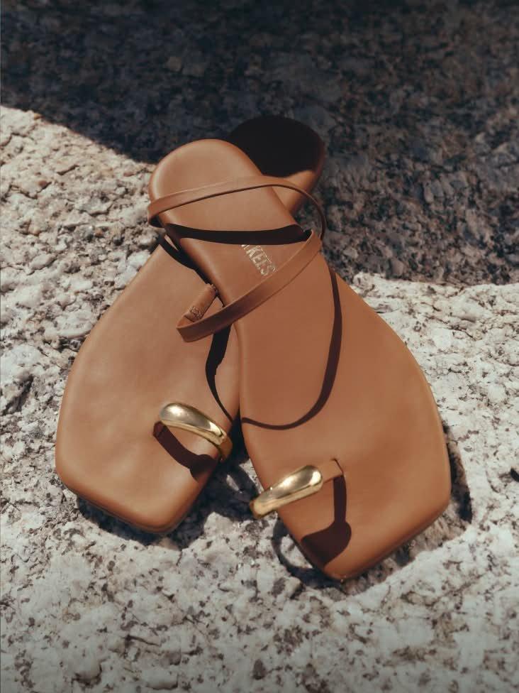 a pair of tan sandals with gold rings on them