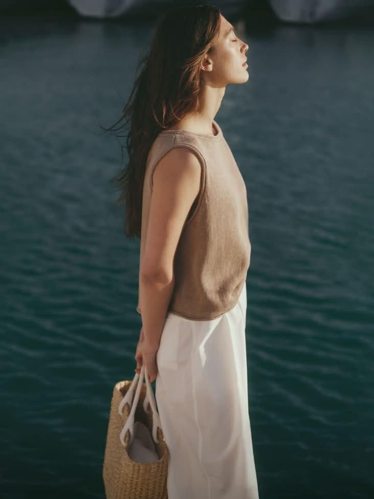 a woman standing on a dock with a basket on her shoulder