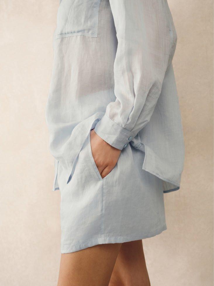 a woman in a blue shirt and shorts standing up