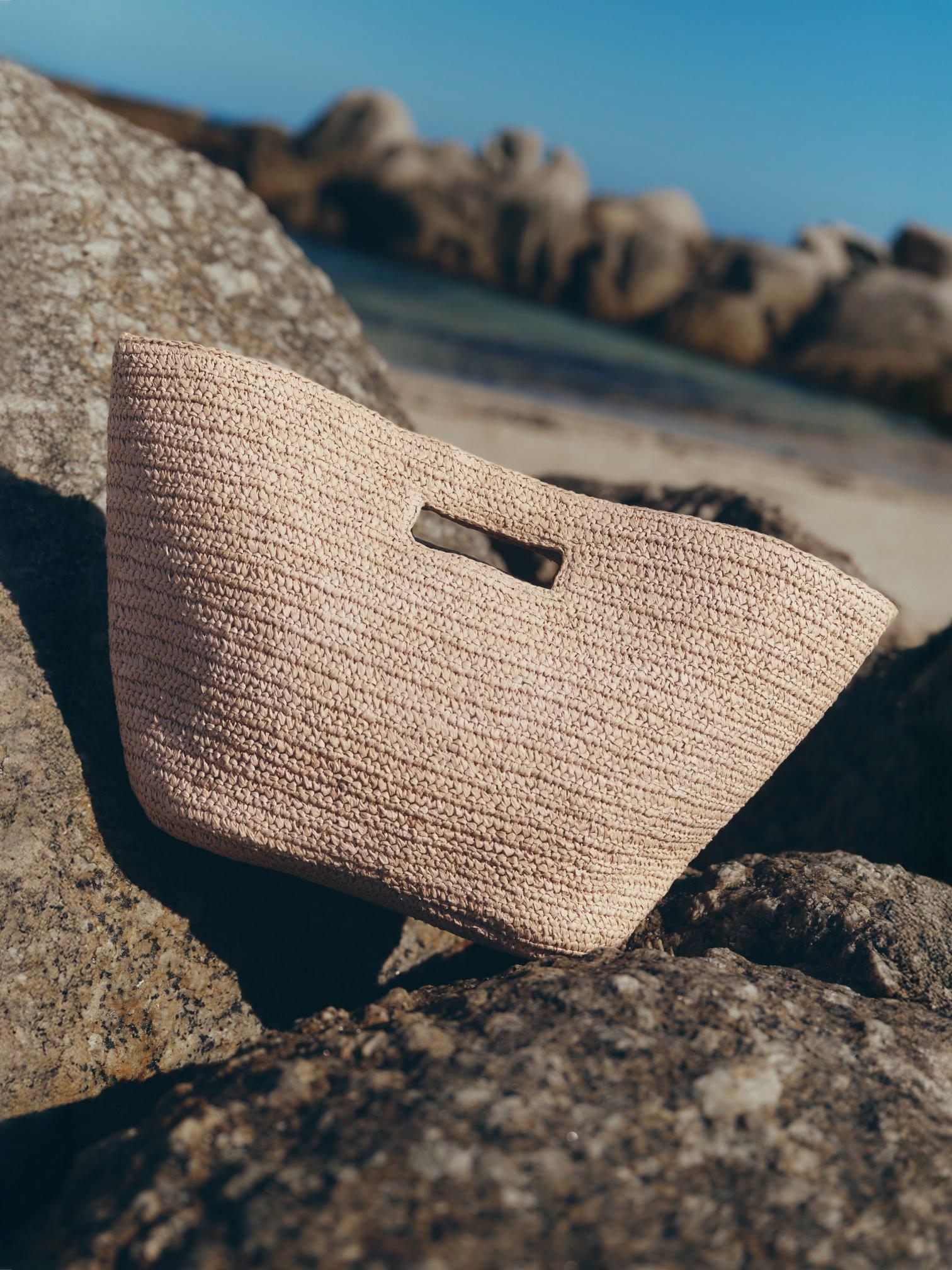 a bag laying on top of a rock on the beach