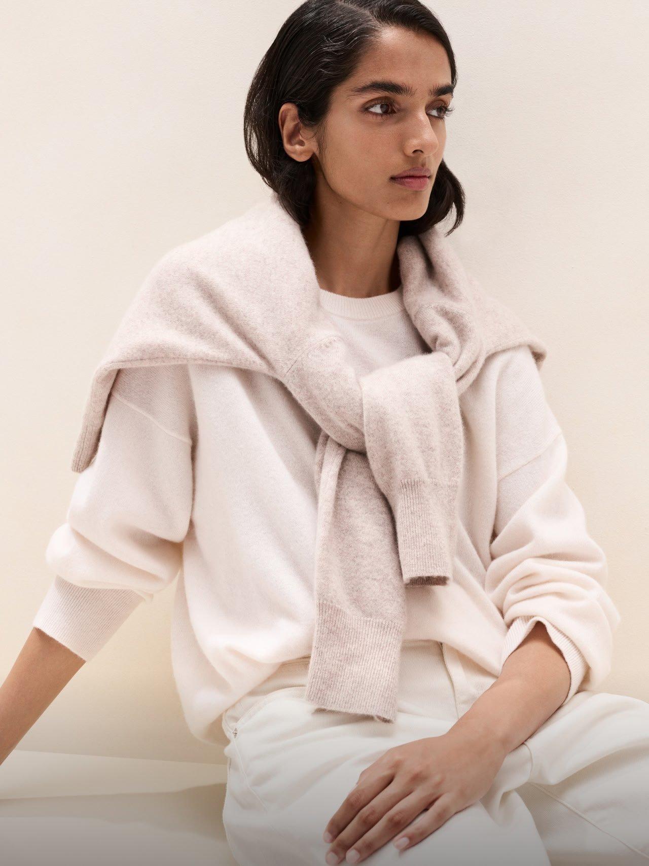 a woman in a white sweater posing for a picture