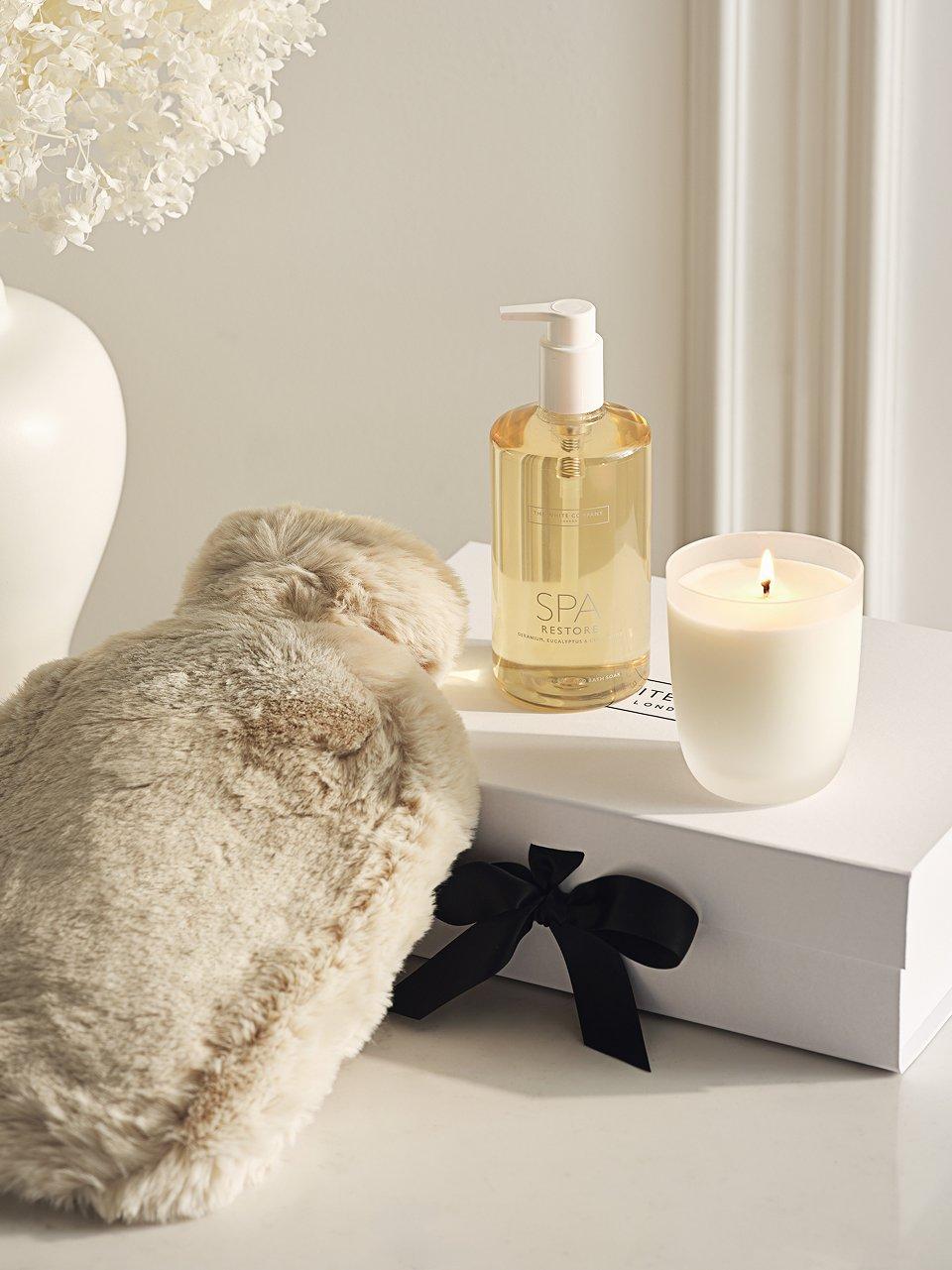 a white candle, a hot water bottle and a candle holder