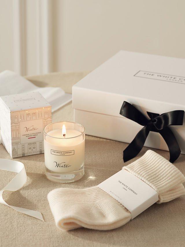 a candle, a box, and a pair of socks on a table