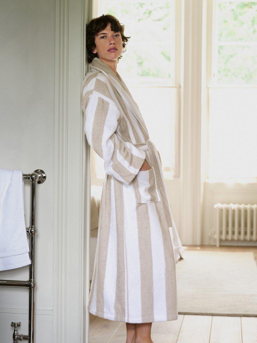 a woman in a white robe sitting on a bathtub