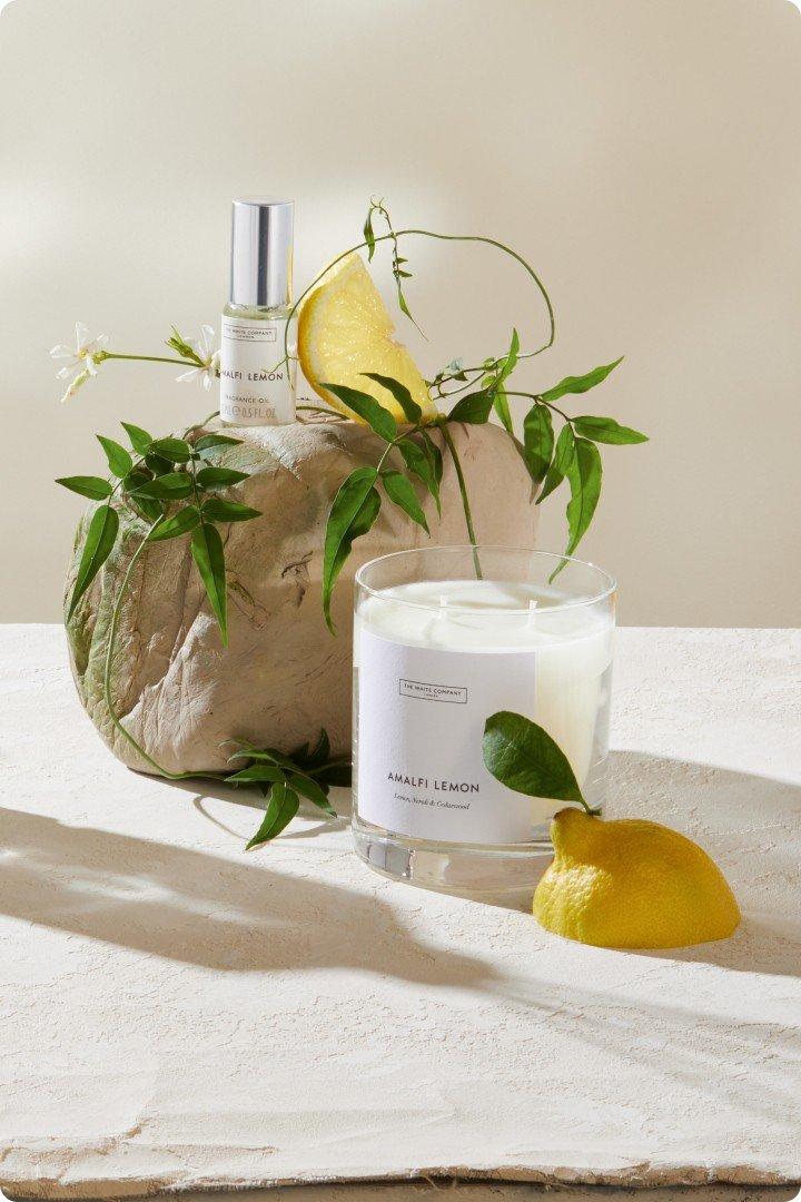 a candle and lemon on a table next to a rock