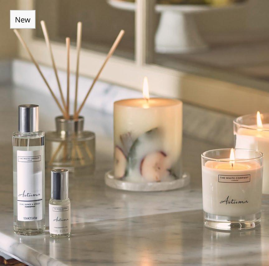 a marble counter top with candles, perfumes and other items
