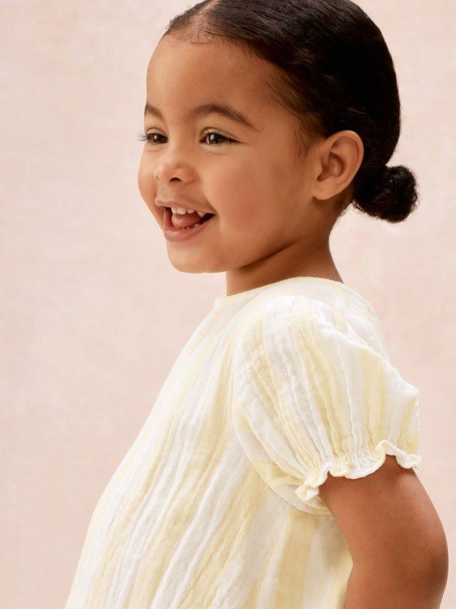 a little girl in yellow set