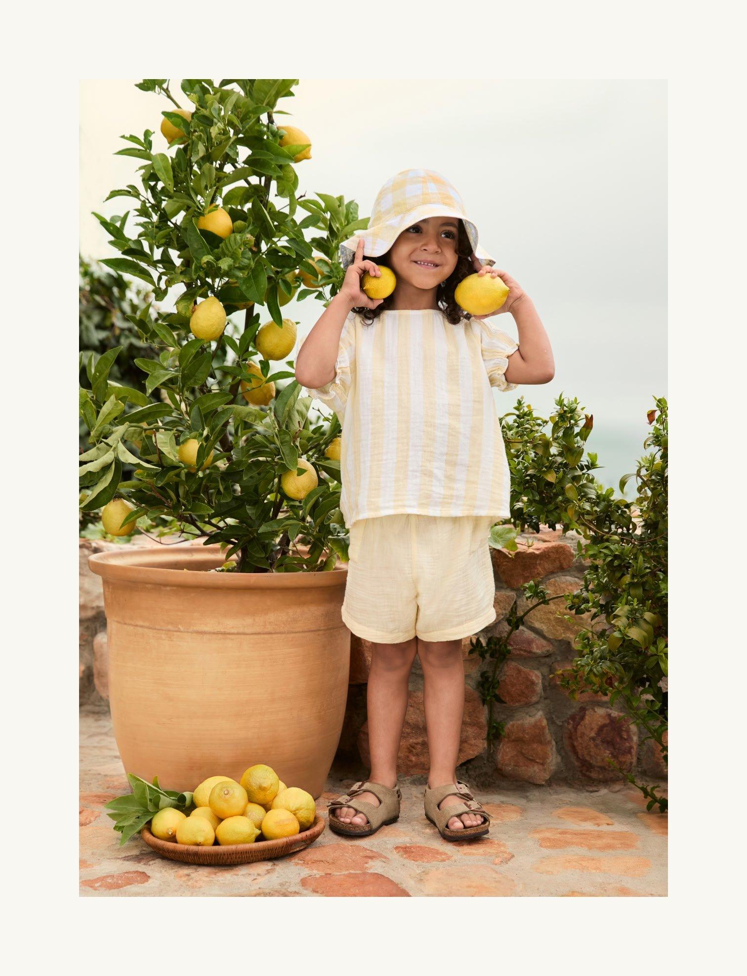 a little girl with a hat and lemon on her head
