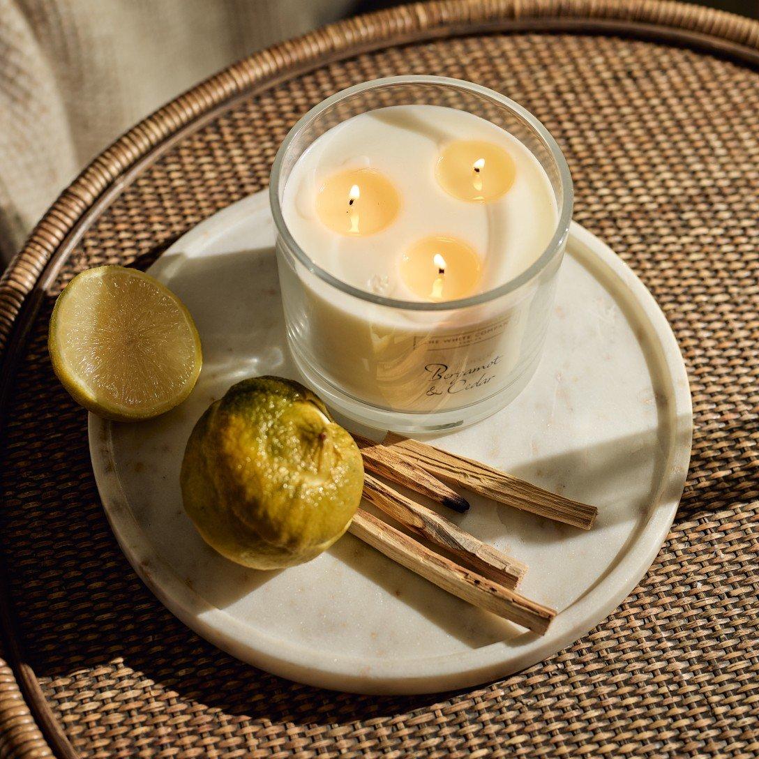 a candle on a plate with leaves and a leaf on the plate