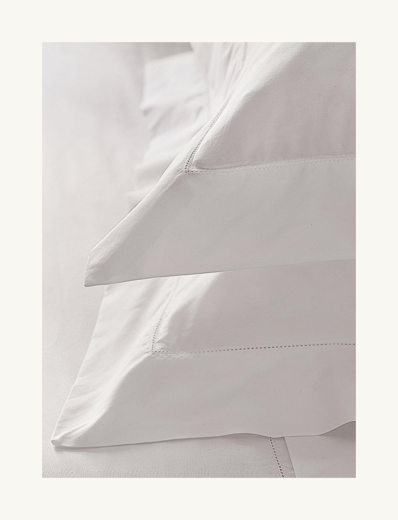 a close up of a yellow dot on a white pillow