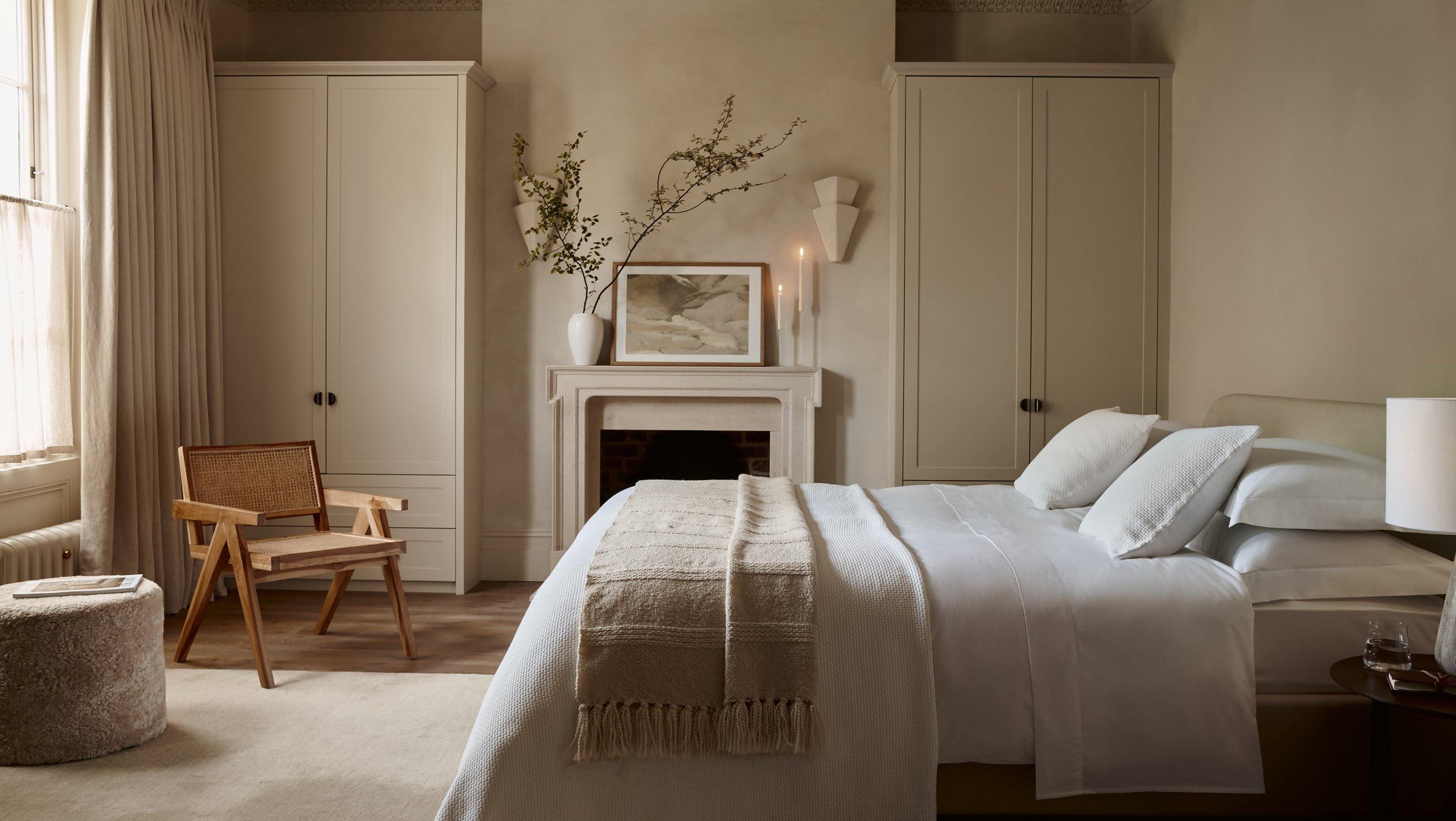 a bedroom with a bed, fireplace, and a chair in it