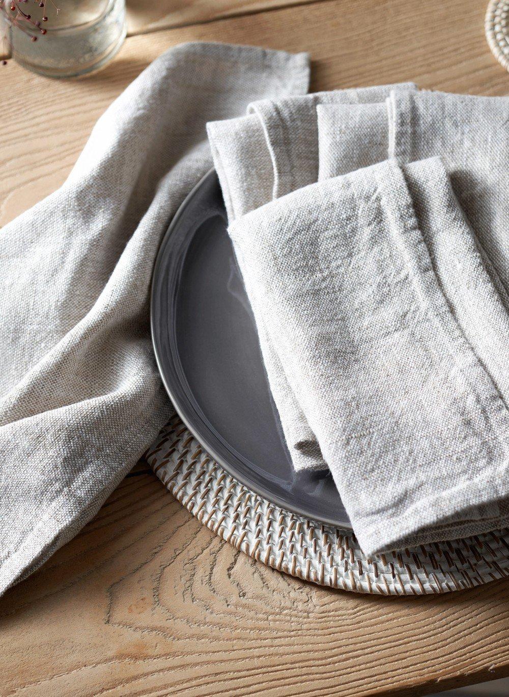 a stack of folded napkins on a plate on a table