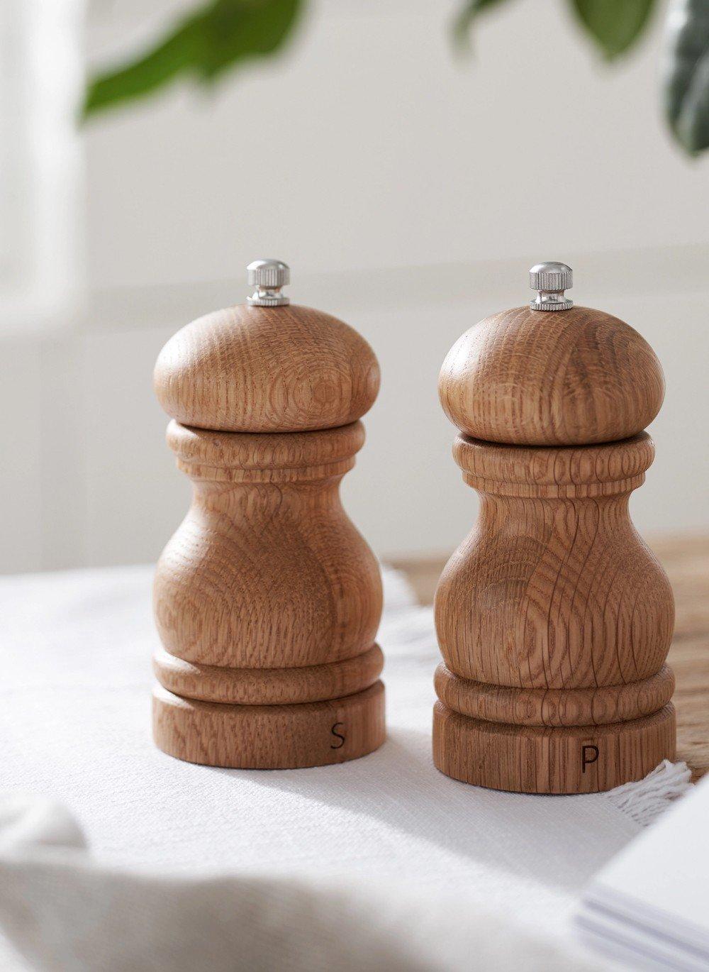 two wooden salt and pepper shakers on a table next to a book