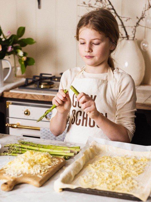 two children are making a chocolate cake on a table