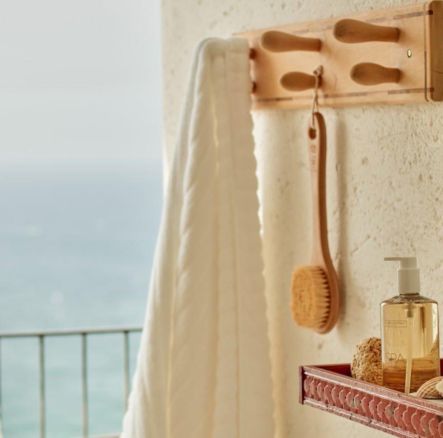 a bathroom with a towel rack and a shelf with a bottle of shampoo