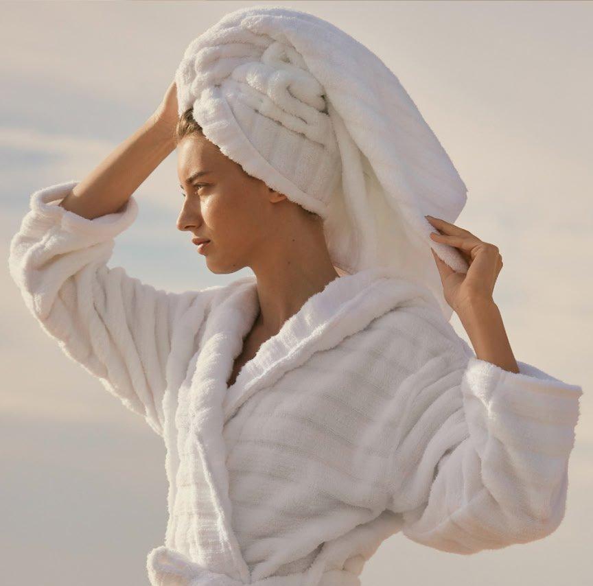 a woman in a white robe is standing in the sand