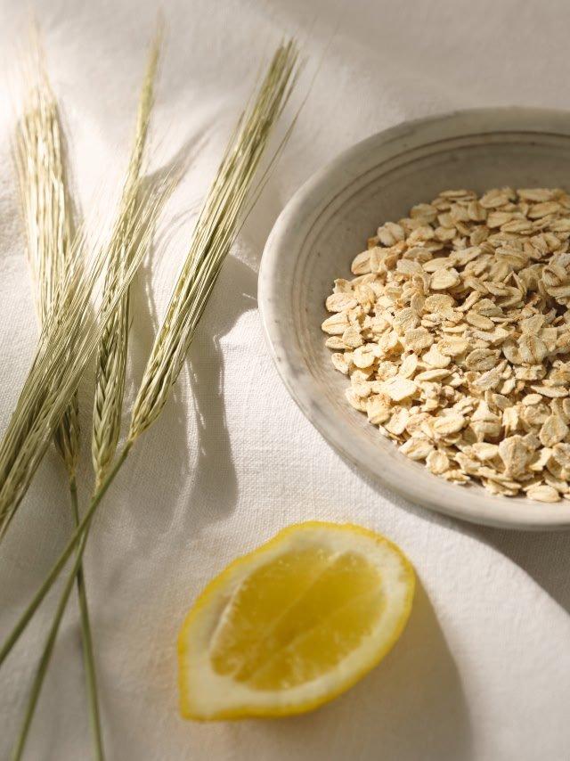 a bowl of oats and a lemon on a white cloth
