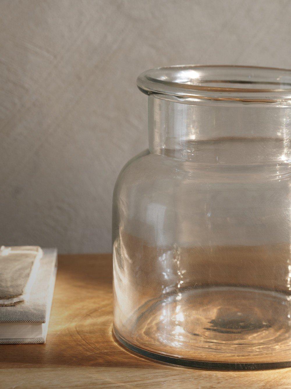 a glass bowl sitting on a table with a flower vase