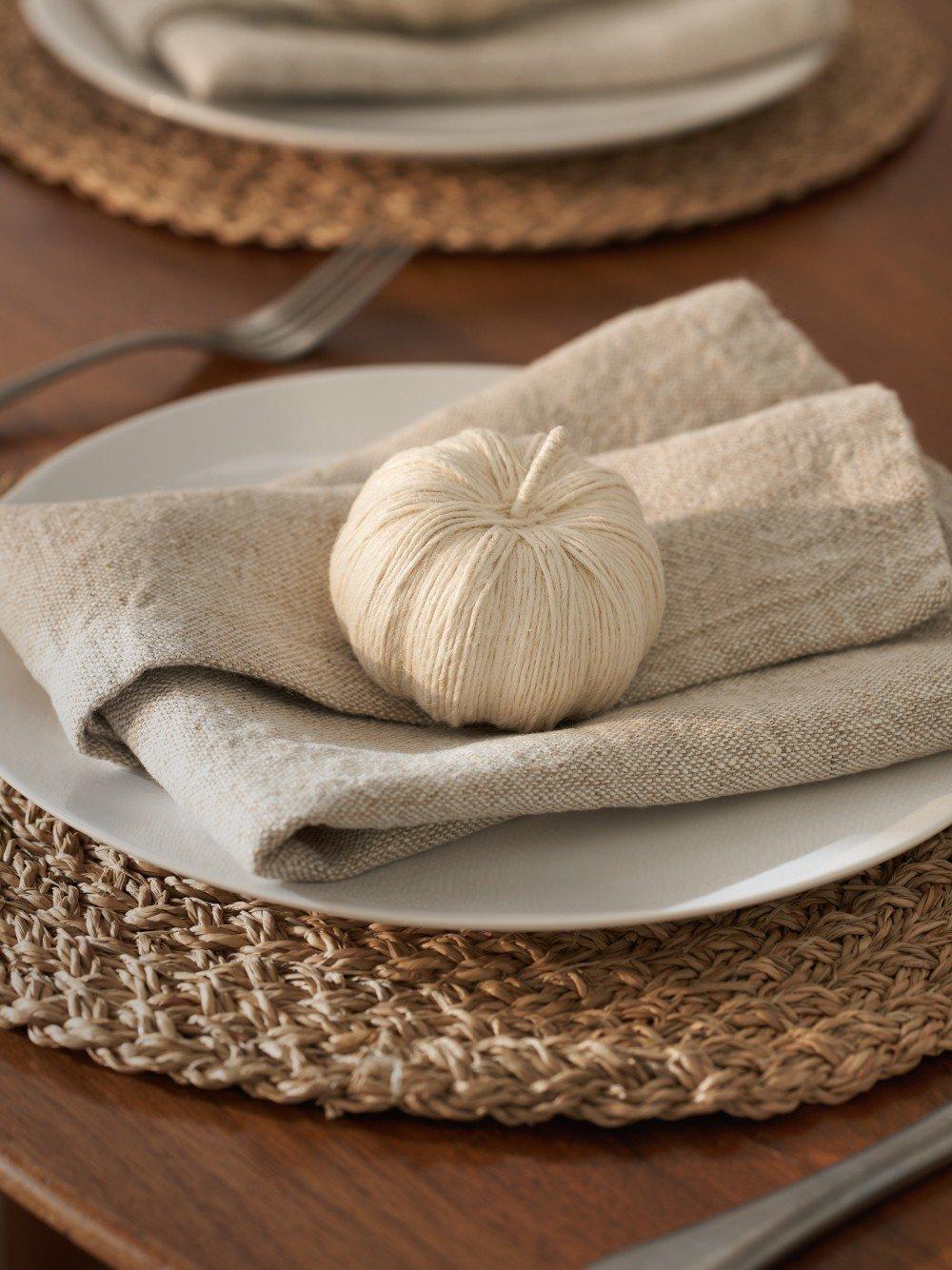 a white bowl sitting on a wooden table next to a towel