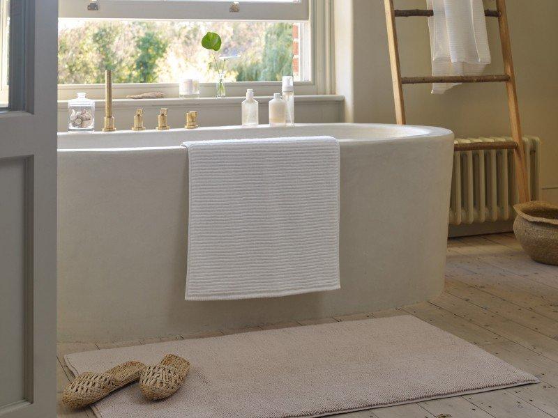 a bathroom with a bathtub and a window with a ladder