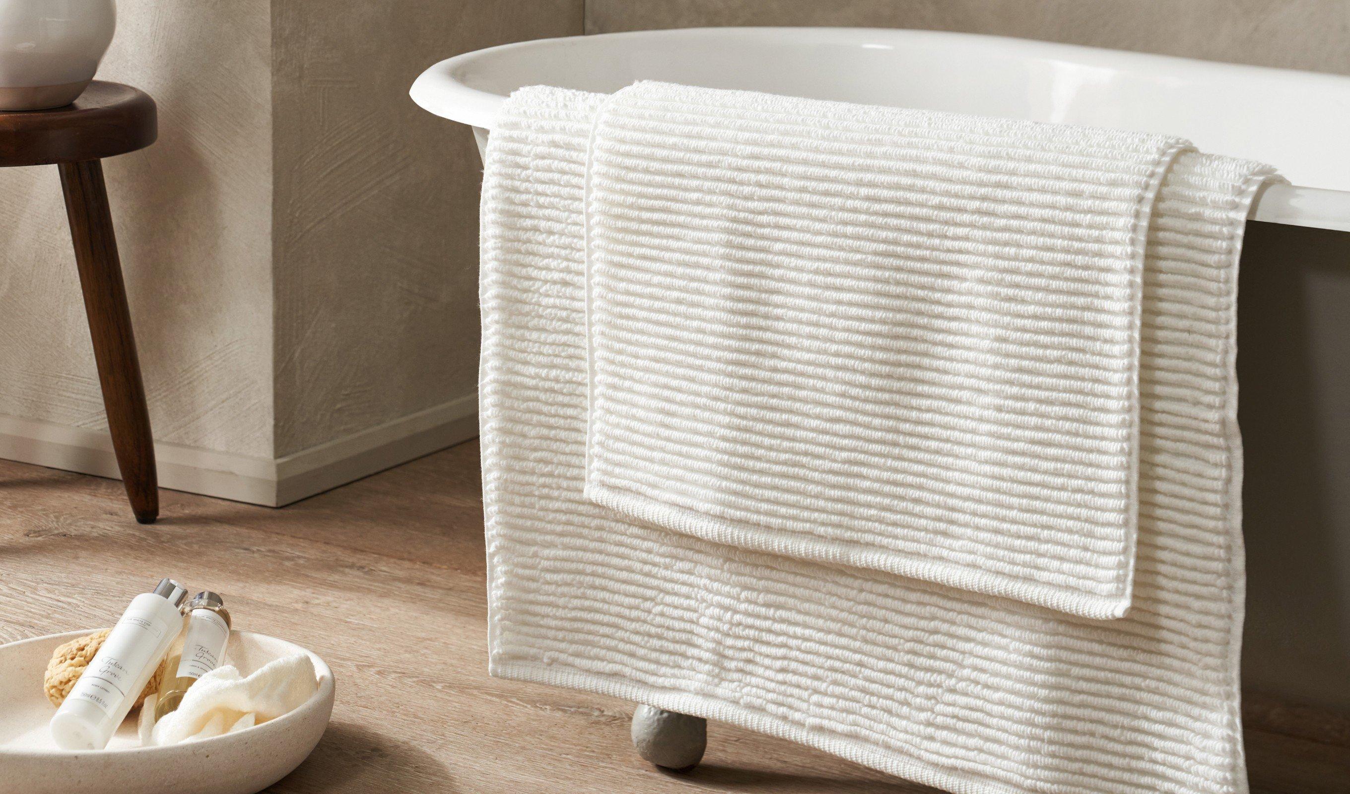 a bathtub with a towel on it next to a bowl