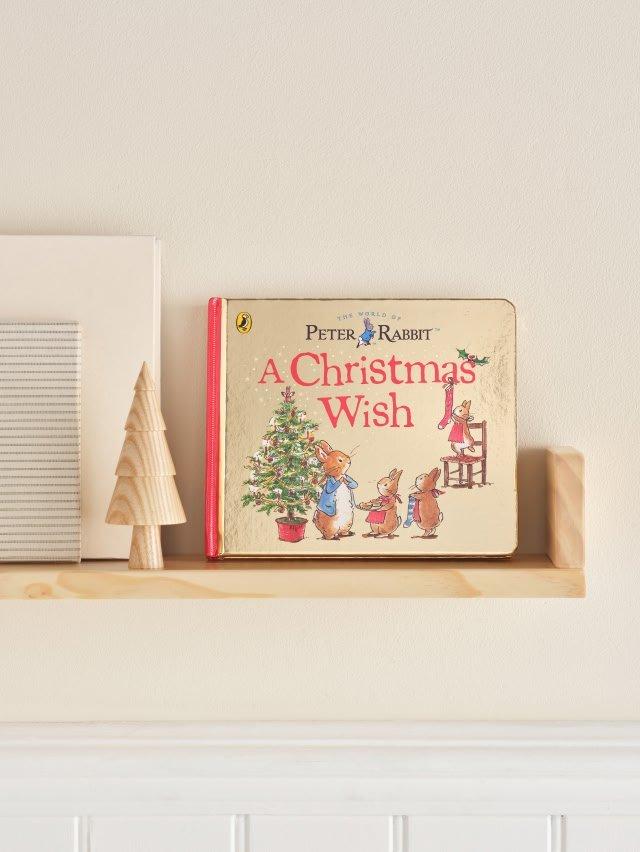 a christmas wish book on a shelf next to a christmas tree