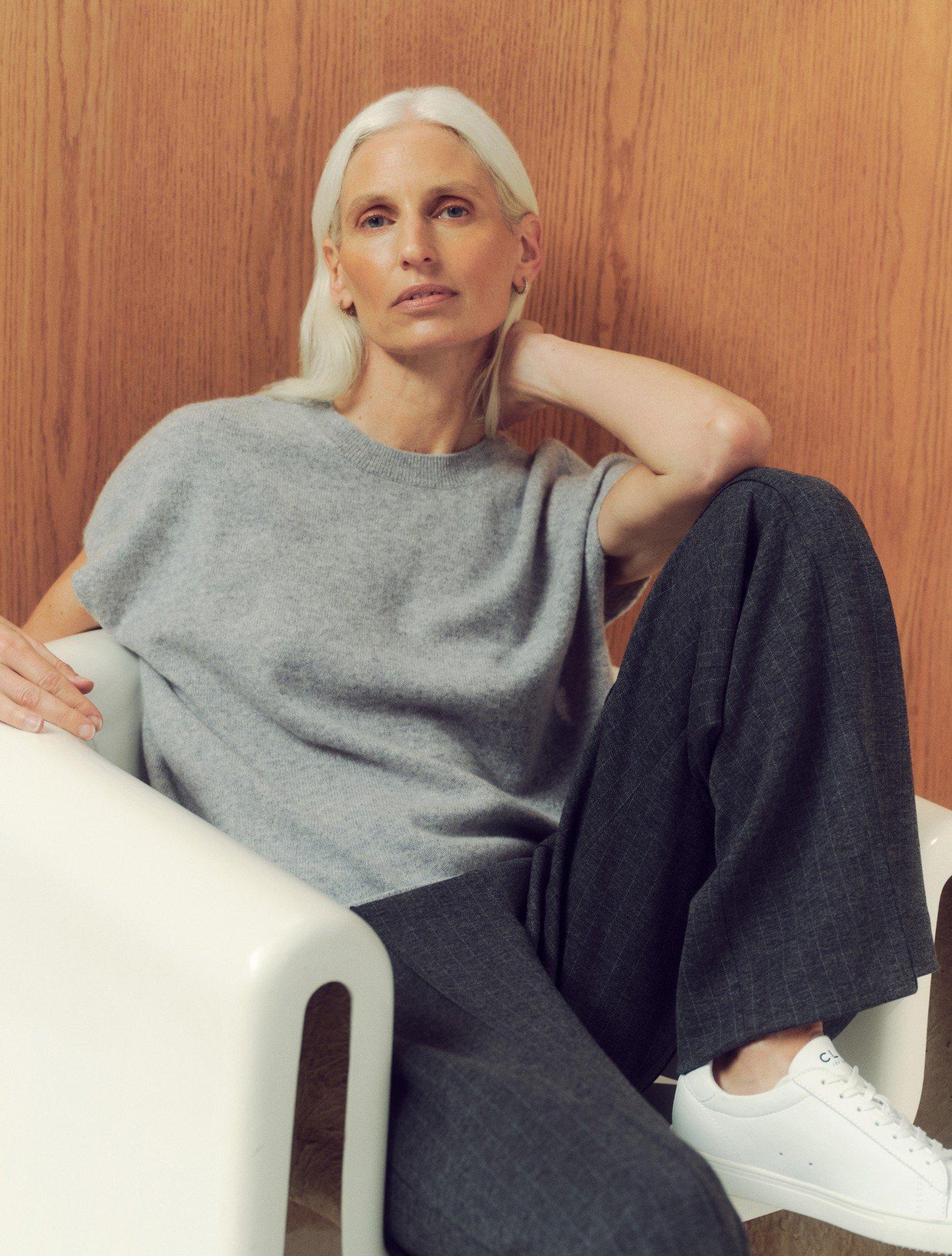 a woman sitting on a chair with her feet up