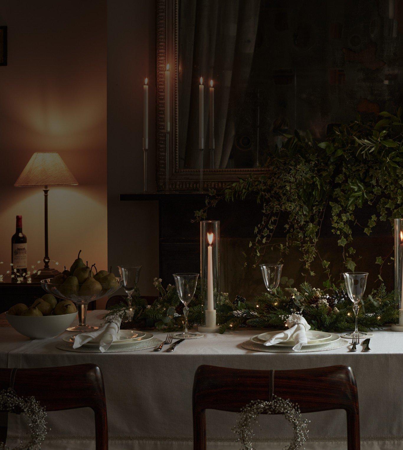 a table set for a formal dinner with candles and flowers