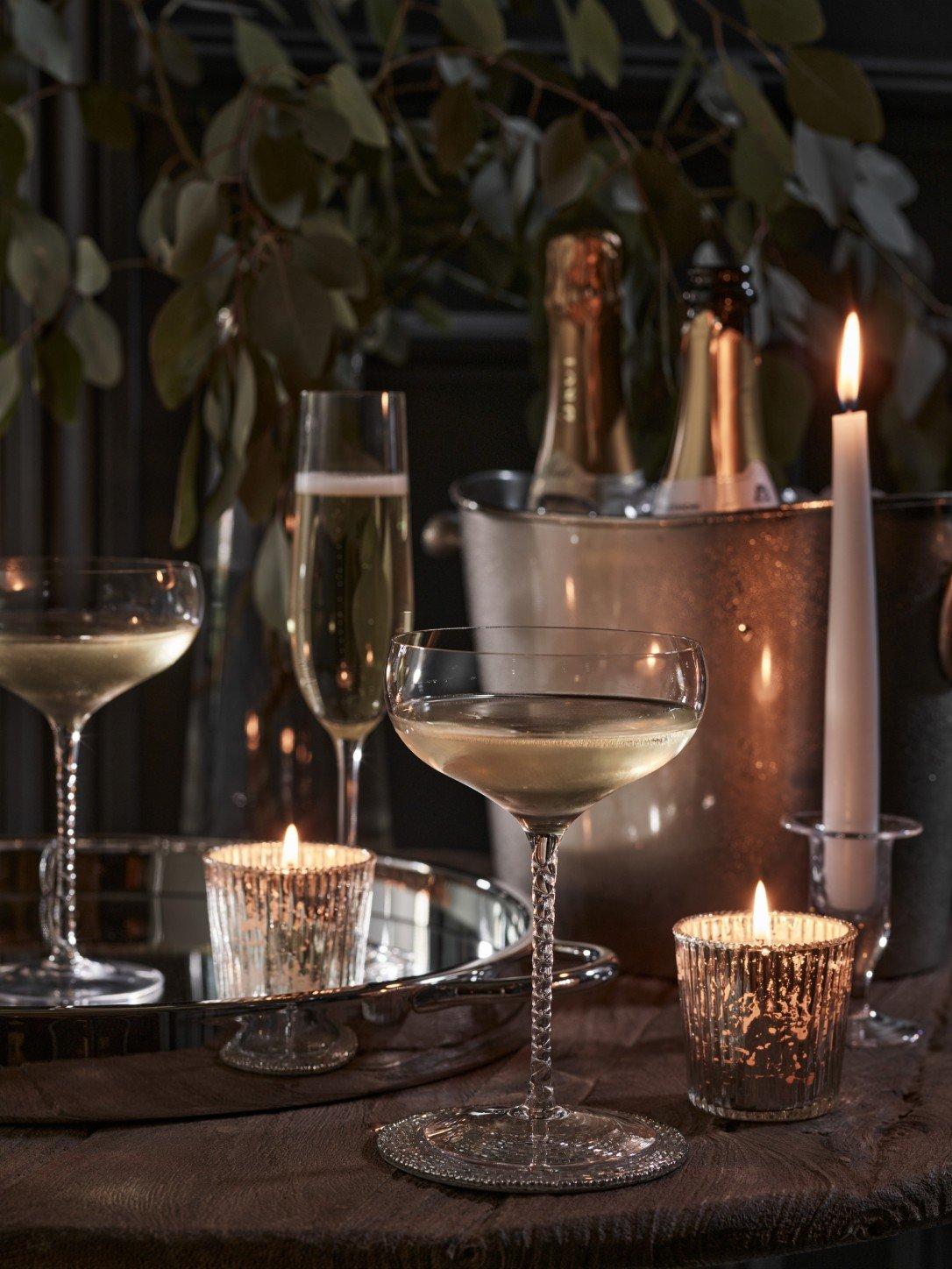 a table with two glasses of champagne and a candle