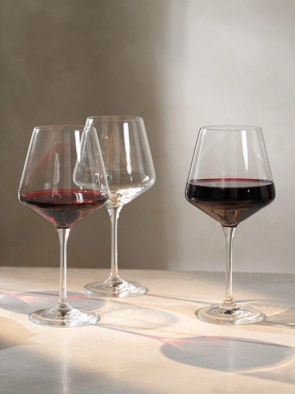 three wine glasses are filled with red and white wine