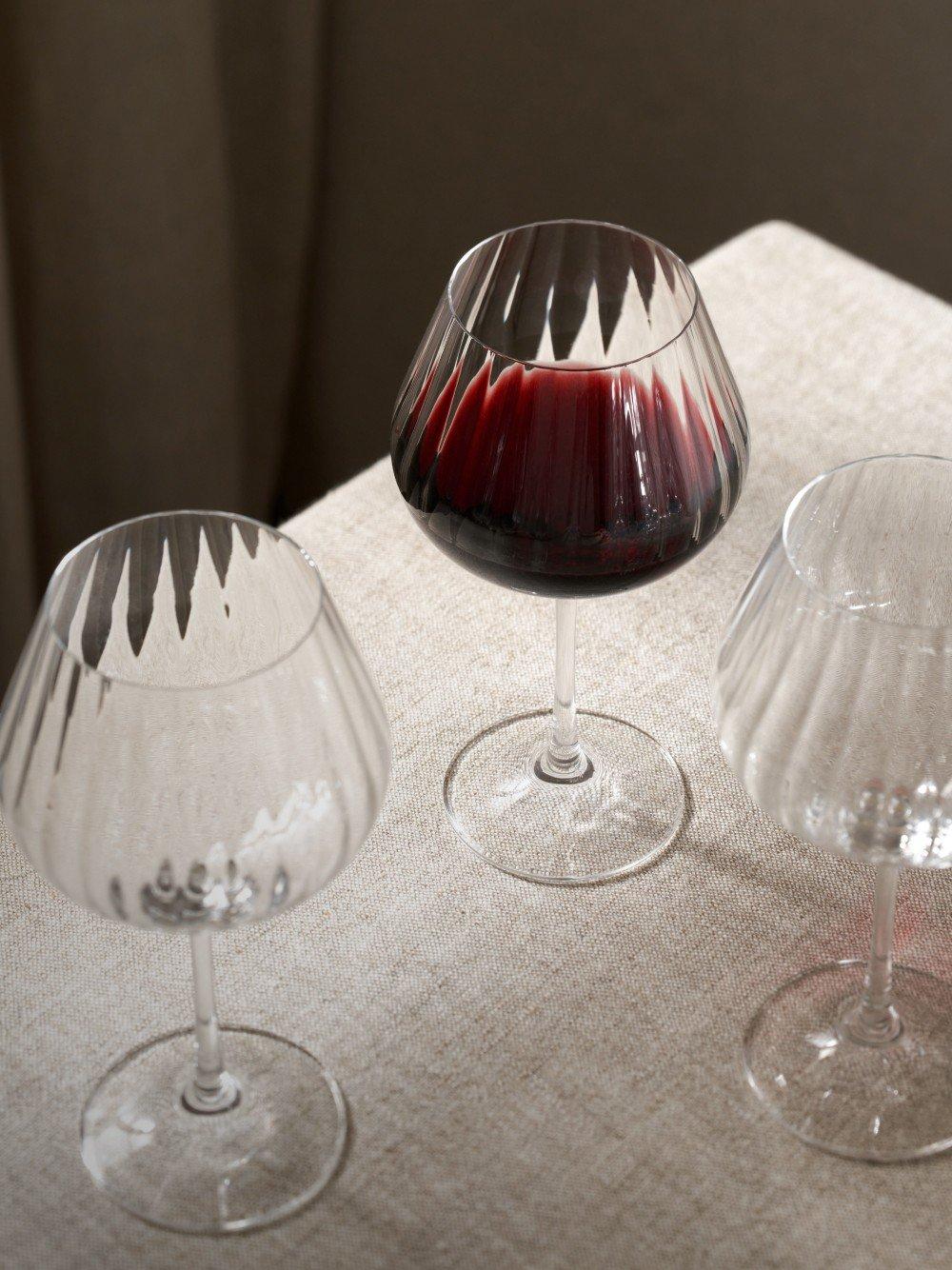 three wine glasses on a table with a white cloth covering them