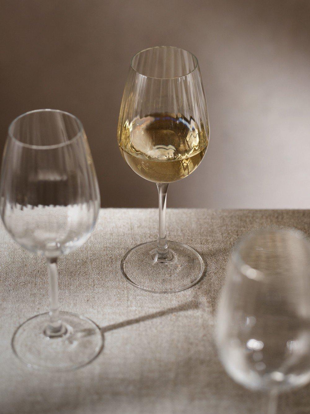 a close up of two wine glasses on a table with a white wine