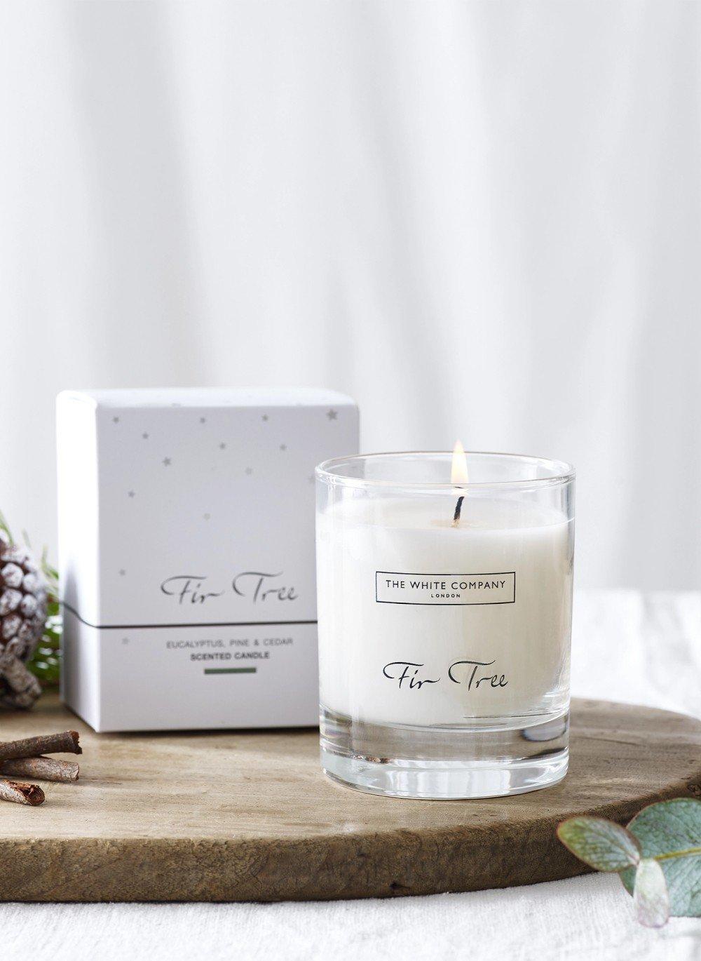 a candle sitting on a wooden tray next to a box of cinnamon