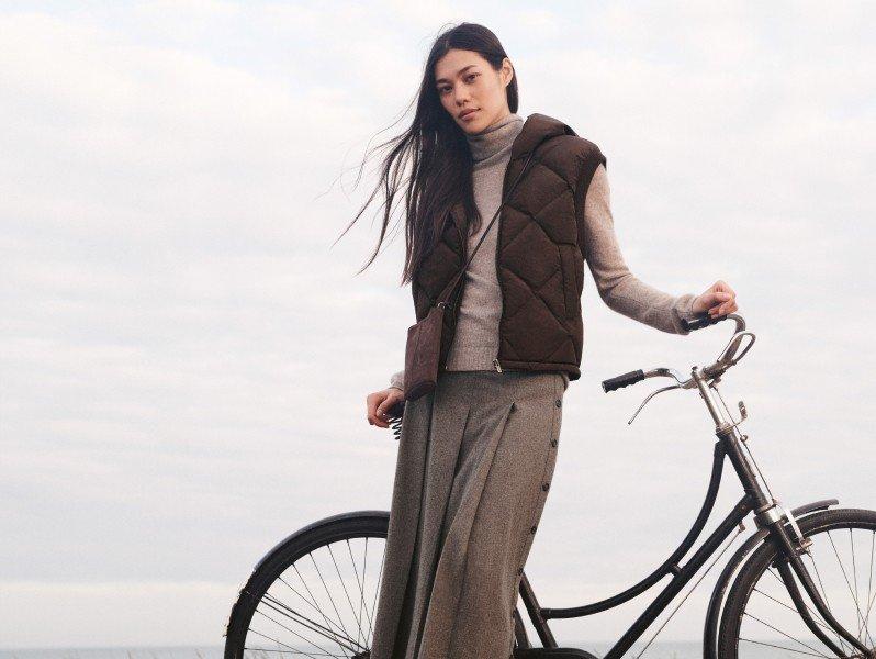 a woman leaning on a bike and a woman posing with a dog